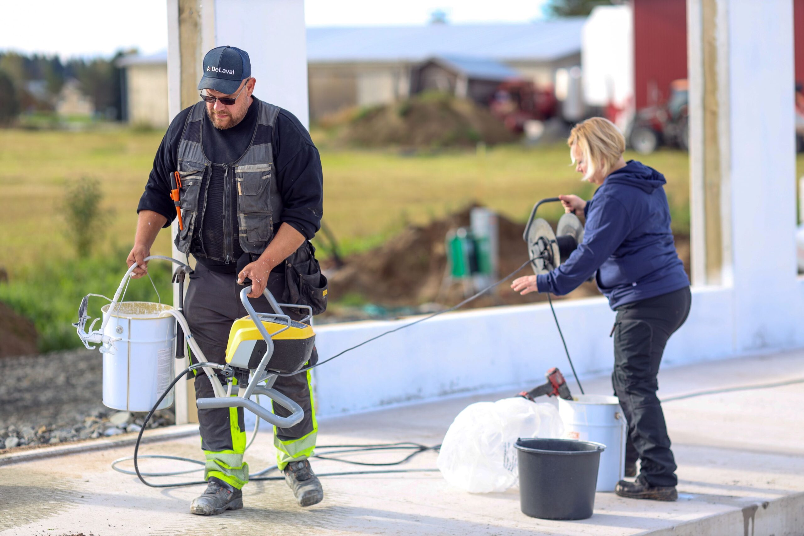Kesä on ollut työntäyteinen, mutta arki sujuu navetan rakentamisen ohellakin, kun jokainen tietää paikkansa ja kommunikointi toimii. Maalauspuuhissa Päivi ja Jouni Kaustinen.